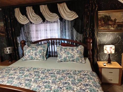sypialnia z drewnianym łóżkiem z poduszkami i oknem w obiekcie Apartmani Jozić w mieście Garešnica