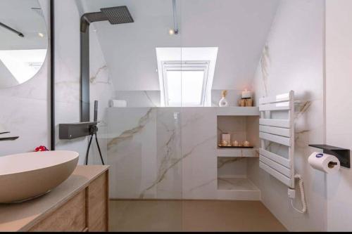 a white bathroom with a sink and a shower at Moderne studio in Nieuwpoort
