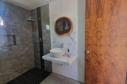 a bathroom with a sink and a shower with a mirror at Yyy in Cancún