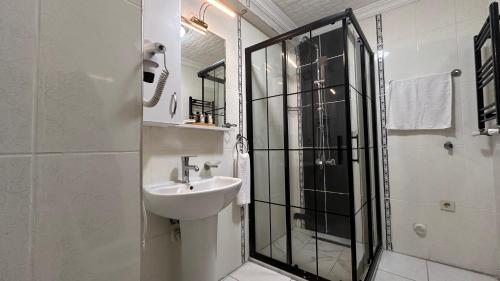ein weißes Badezimmer mit Waschbecken und Dusche in der Unterkunft Overland Residence in Istanbul