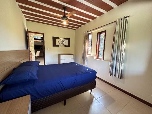 um quarto com uma cama azul num quarto em Mega Casa em sítio churrasco piscina em Ipiabas RJ em Barra do Piraí