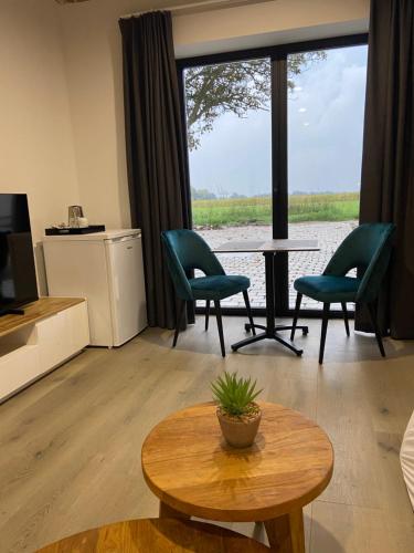 a living room with a table and chairs and a large window at HVN10 - Near Antwerp in Stabroek