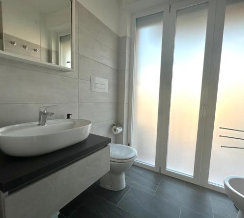 biała łazienka z umywalką i toaletą w obiekcie MiPA w mieście Milazzo