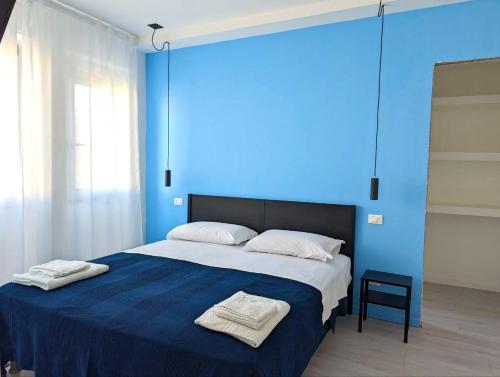 niebieska sypialnia z łóżkiem z dwoma ręcznikami w obiekcie MiPA w mieście Milazzo