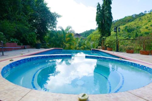 ein großer Swimmingpool mit einer Spiegelung des Himmels in der Unterkunft Cascade Mountain View Oasis in Port of Spain