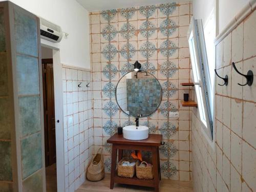baño con espejo en la pared de azulejos en Valle de la Rosa en Prado del Rey