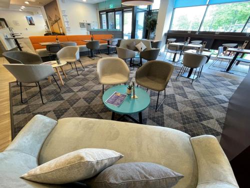 a living room with a couch and chairs and tables at Holiday Inn Express Middlesbrough - Centre Square by IHG in Middlesbrough
