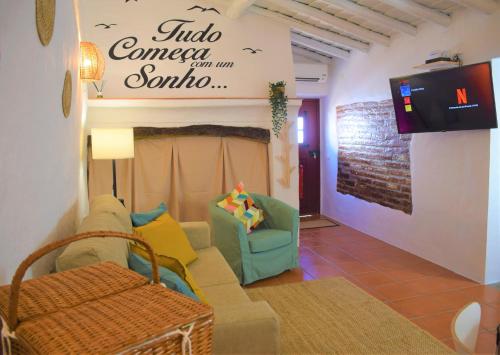 a living room with a couch and a tv at Casa da Chaminé - Refúgio com Charme Alentejano in Amieira