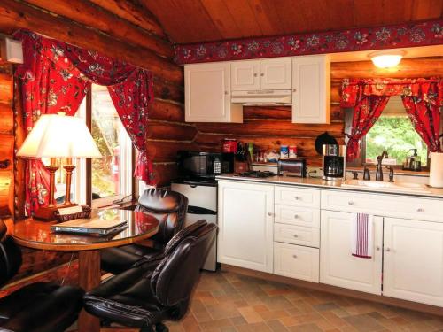 una cocina con mesa y sillas en una cabaña en A Cabin on the Cliff en Seward