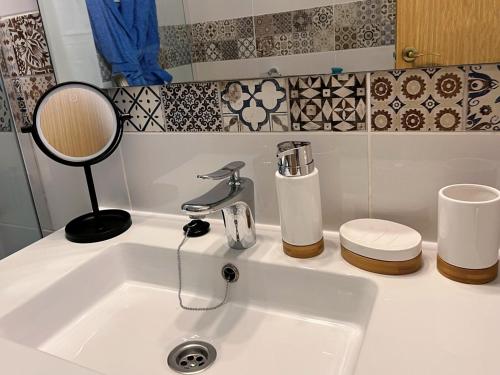 eine Badezimmertheke mit einem Waschbecken und einem Spiegel in der Unterkunft Cactus del Mar in Tarajalejo