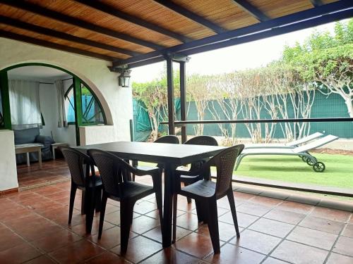 uma sala de jantar com uma mesa e cadeiras num pátio em Bungalow en el sur de Gran Canaria em Las Palmas de Gran Canaria