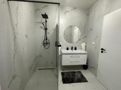 Baño blanco con lavabo y espejo en Klimatizovaný Apartmánový dom s vírivkou, 9A, en Senec