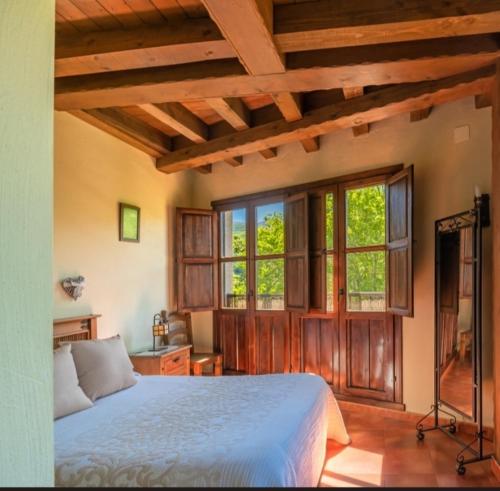 1 dormitorio con 1 cama grande y ventanas en Complejo Rural Las Palomas, en Jerte