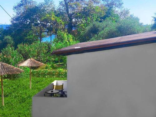 a patio with two chairs and a table and umbrellas at Blue Bay Beach Hotel in Kinira