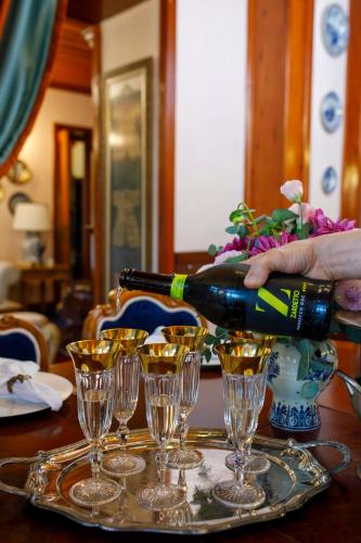 a person pouring a bottle of wine into wine glasses at Hotel Bosnali in Adana
