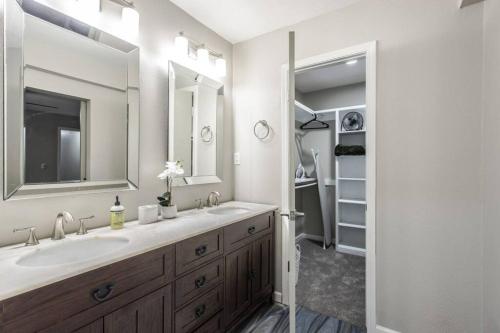 ein Badezimmer mit zwei Waschbecken und einem großen Spiegel in der Unterkunft NEW Hummingbird Haven - NW OKC, Billiards, Firepit in Oklahoma City