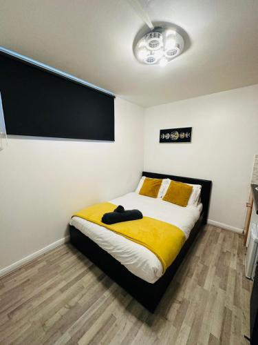 Premium Studio Flat 08 in Central London في لندن: غرفة نوم بسرير كبير مع بطانية صفراء