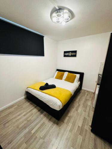 Premium Studio Flat 08 in Central London في لندن: غرفة نوم بسرير وبطانية صفراء