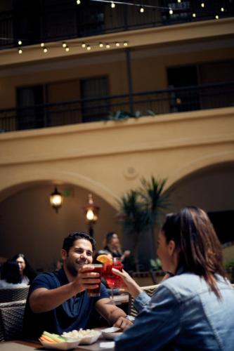 a man sitting at a table drinking from a glass at Embassy Suites by Hilton Los Angeles International Airport South in El Segundo