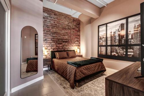 a bedroom with a bed and a brick wall at NYC Styled Loft In DTLA, sleeps 4 with Free Parking! in Los Angeles