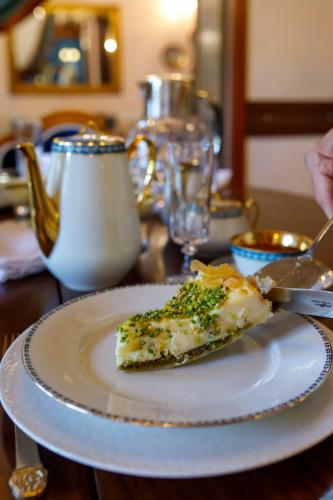 a piece of pizza on a white plate on a table at Hotel Bosnali in Adana