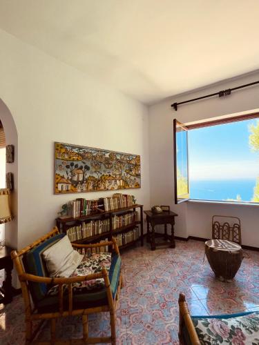 a living room with a large window and a couch at Villa Rosanna in Massa Lubrense