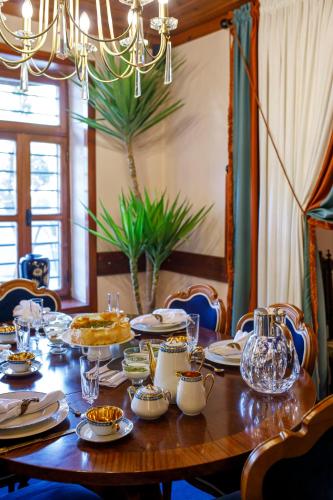 a wooden table with plates and glasses on it at Hotel Bosnali in Adana