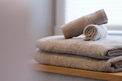 stos ręczników na drewnianej półce w obiekcie Kapitel 7 Boutique-Hotel w mieście Raron
