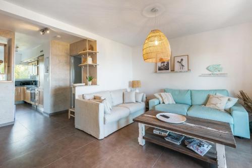 een woonkamer met een blauwe bank en een tafel bij Appartement de la Montée - Welkeys in Bandol