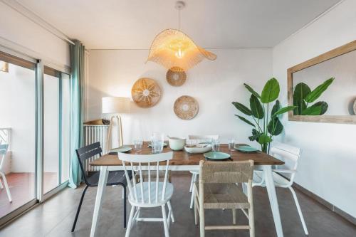 une salle à manger avec une table et des chaises en bois dans l'établissement Appartement l’Eden Azur - Welkeys, à Bandol