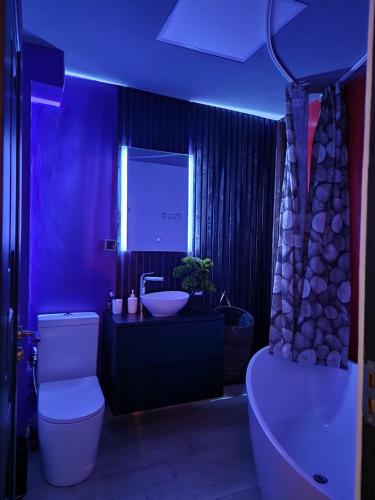 a bathroom with a toilet and a sink with a blue light at D2 ASP - VIVO Mall in Floreşti