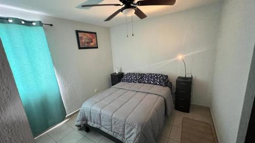 um quarto com uma cama e uma ventoinha de tecto em Juan Renteria em Tijuana