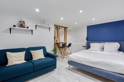 - une chambre avec un lit et un canapé bleu dans l'établissement Rent a Room - Residence Caire, Montorgueil, à Paris