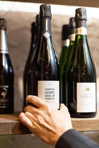 a person holding a card in front of three bottles of wine at Maison Flipot in Torre Pellice