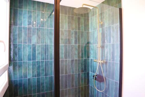 ein Bad mit einer Dusche und blauen Fliesen in der Unterkunft T3 Lyon 8 parc parilly-Eurexpo -9min en voiture in Vénissieux