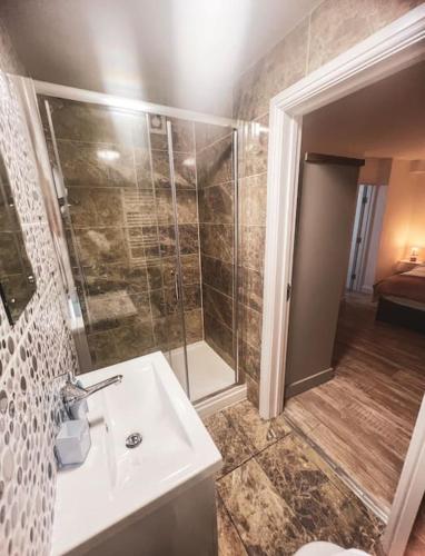 a bathroom with a shower and a white sink at Newly furnished Apartment, Leicester City Centre in Leicester