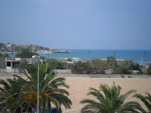 um parque de estacionamento com palmeiras em frente ao oceano em Appartamenti Bramante em Vieste