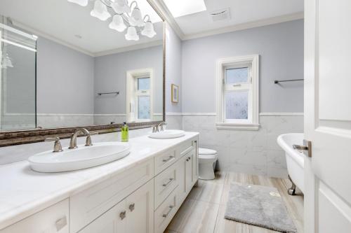 a bathroom with two sinks and a tub and a toilet at Vancouver Haven: Luxurious Private Bedroom near Attractions in Vancouver