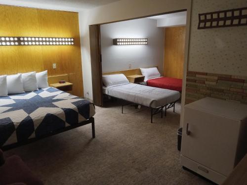 um quarto de hotel com uma cama e uma cama e uma porta em Siesta Motel em Havre