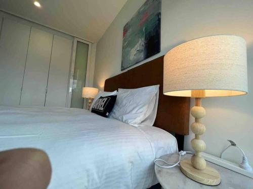 a bedroom with a bed and a lamp on a table at Nest Apartments on Rose Lane in Melbourne
