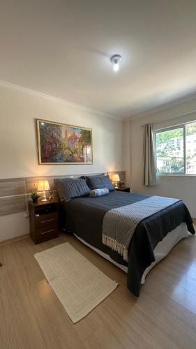 1 dormitorio con 1 cama grande y 2 ventanas en Apto Alamanda - Aconchegante, Confortável e bem localizado!, en Piratuba