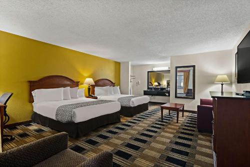 een hotelkamer met 2 bedden en een televisie bij Best Western Windsor Suites in Fayetteville