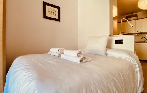 Una cama blanca con toallas encima. en Click&Guest - Studio La Lajilla, en Mogán