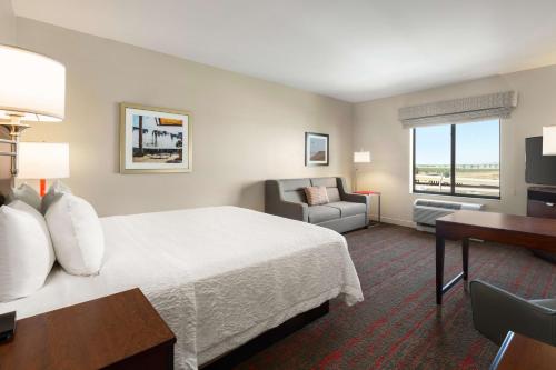 a hotel room with a bed and a desk and a chair at Hampton Inn & Suites Phoenix Glendale-Westgate in Glendale