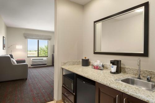 a hotel room with a sink and a mirror at Hampton Inn & Suites Phoenix Glendale-Westgate in Glendale