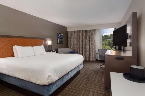 ein Hotelzimmer mit einem Bett und einem Flachbild-TV in der Unterkunft Hampton Inn Bristol in Bristol