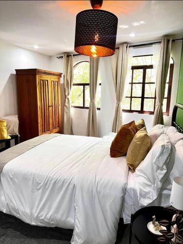 Un dormitorio con una gran cama blanca y una ventana en Casa Olivo, en Ciudad de México