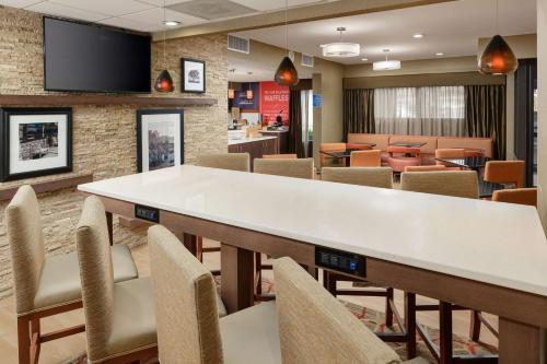 una sala de espera con una mesa grande y sillas en Hampton Inn Oak Ridge Knoxville, en Oak Ridge