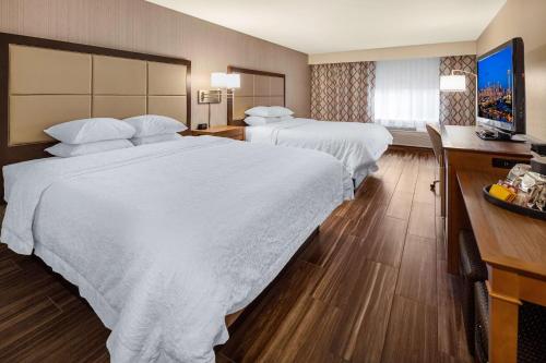 a hotel room with two beds and a desk at Hampton Inn & Suites Seattle North/Lynnwood in Lynnwood