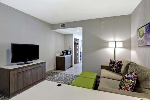 a living room with a couch and a flat screen tv at Hilton Garden Inn Toronto/Ajax in Ajax